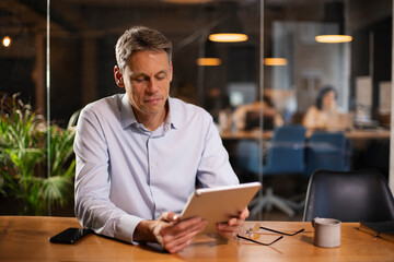 Portrait of businessman in office. Man using digital tablet. Businessman having video call.