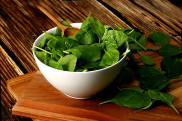 White bowl with raw spinach