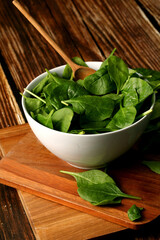White bowl with raw spinach