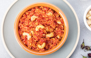 Gajar ka halwa is, Popular Indian dessert pudding made with grated carrots, milk, sugar and nuts served hot with a garnish of almonds, cashew nuts and pistachios.
