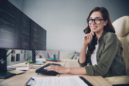 Profile side photo of smiling charming lady hand on keyboard typing java script keys create interface modern app indoor room workstation