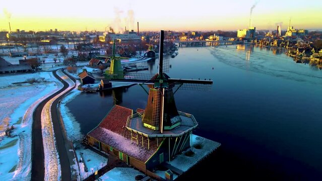 snow covered windmill village in the Zaanse Schans Netherlands during winter weather, historical wooden windmills in winter Zaanse Schans Holland during winter. 