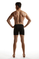 Fototapeta premium Rear view photo of mature handsome man posing shirtless in black boxers over white studio background. Strong back. Men's health and beauty