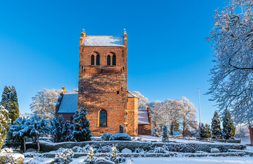 Fototapeta na wymiar Skevinge Church in Denmark in frosty winter with ice and snow