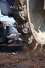 Bucket-wheel excavator during excavation at the surface mine. Huge excavator on open pit mine.	