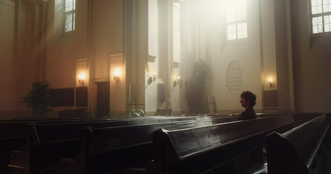 Spiritual Man Sitting and Praying in the Church. Parishioner Feeling the Connection to the God. Belief Goodness and Kindness through Religion and Spirituality. Contemplation in Christian Cathedral