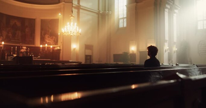 In A Grand Old Church, A Devout Christian Sits, finding Comfort in Faith. Contemplating Life, Seeking Moral Guidance. Sacred Space is Filled With Religious Atmosphere, Providing Solace To The Faithful
