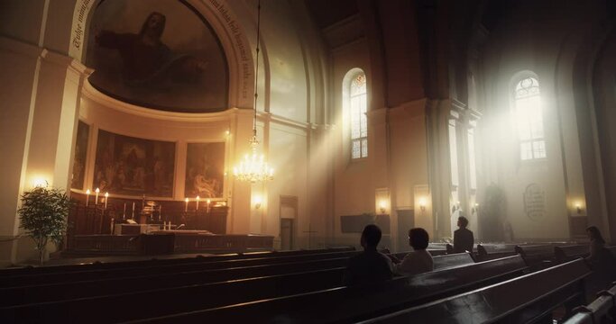 Group Of Faithful Parishioners In Grand Old Church. Congregation of Christians Seeking Comfort In Faith And Religious Beliefs. Sitting Piously, Praying, Seeking Guidance from God. Wide Static Shot