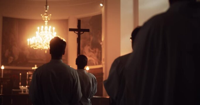 Liturgy In Church: Procession Of Ministers, Bearing Holy Cross to Altar, As Congregation Stands In Wonder. Christians Rejoice In Celebration Of Divine Mass. Hymns Praise God. Slow Motion Following