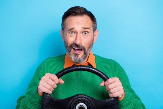 Portrait of mature aged grey hair man wear green jumper shirt driving new car steering wheel shocked accident isolated on blue color background