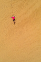 Caucasian white woman relaxing in the dunes. Maspalomas dunes in Gran Canaria, view from above. Peace of mind. Meditation