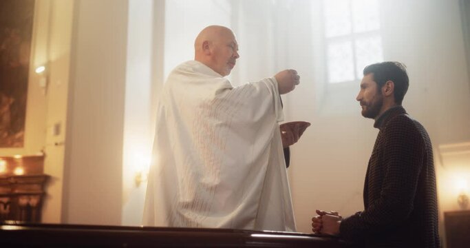 Bishop Symbolically Breaks Communal Bread, Representing The Body Of Christ, And Hands Pieces To Parishioner. Reminder Of Saviors Selfless Sacrifice. Holy Communion, Last Supper, Eucharist in Church