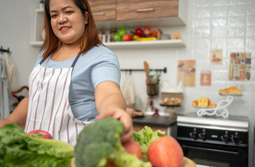 Asian Pregnant learn how to cook healthy meals from the Internet in kitchen, Fat women prepare a vegetable salad for diet food and lose weight. Concept of healthy eating