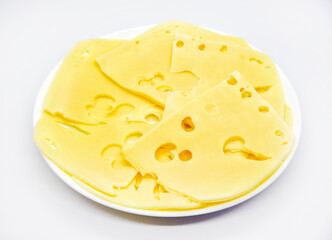 Sliced pieces of yellow cheese with holes on the plate. Chopped cheese close-up. Delicious cheese slices.