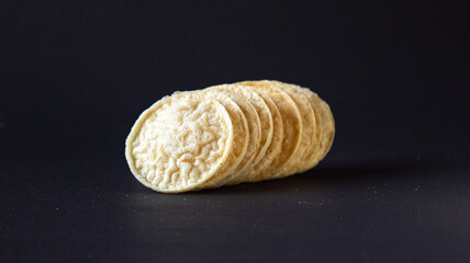 Puffed Chips on black background group shot leaning sideways,  Healthy gourmet snacks