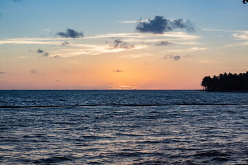 Fototapeta na wymiar Beautiful sunrise at sea. Last minutes before dawn on the Atlantic ocean. The sun beyond horizon. Palm trees against the background of the rising sun. Tropical sunrise. Dominican Republic