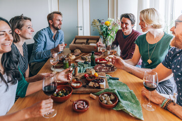 friends sitting around the table eating home delivered tapas food