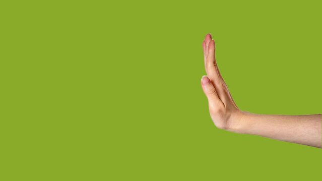 Hand doing stop sign on chroma key background. Gesture animation on green screen background. Refusing something. Side view.