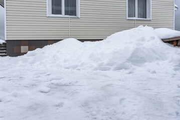 Yard near house are covered with snow.