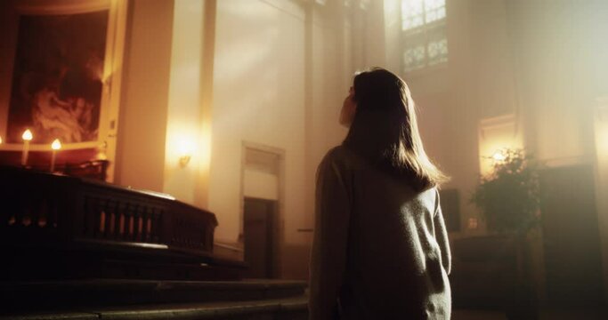 Side View: Christian Woman Getting on her Knees and Starting to Pray in a Church. She Seeks Guidance From her Religious Faith and Spirituality. Spirit of Christianity and Belief in the Goodness of God
