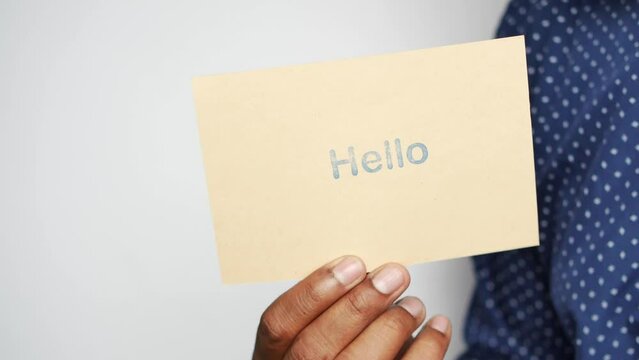  holding a hello text in blue color on a paper 