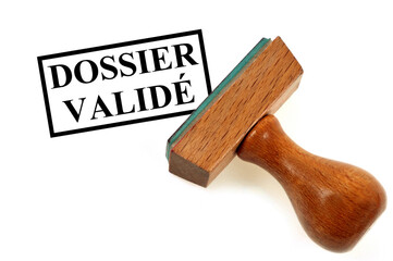 Tampon encreur indiquant dossier validé en gros plan sur fond blanc