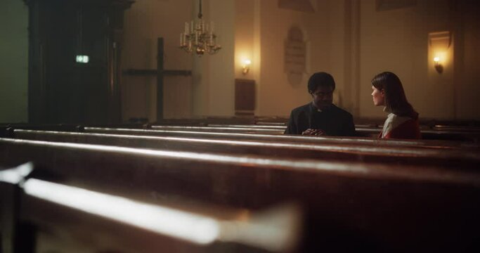 Talk in Church: The Pastor's Gentle Voice Brings Comfort and Solace To Young Parishioner. With Gentle Words of Reassurance, He Reminds a Woman of the Power of Christian Faith and the Love of God