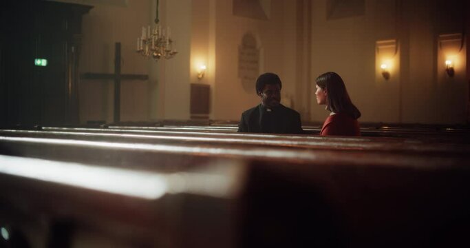 Talk in Church: The Pastor's Gentle Voice Brings Comfort and Solace To Young Female Parishioner. With Gentle Words of Reassurance He Reminds Woman of the Power of Christian Faith and the Love of God
