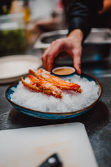 chef cooking crab legs with caviar on kitchen