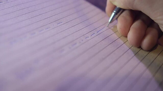 Hand of man holding pen writing symbols of Morse code on paper with lines. Worker notes message in diary to transmit on telegraph closeup