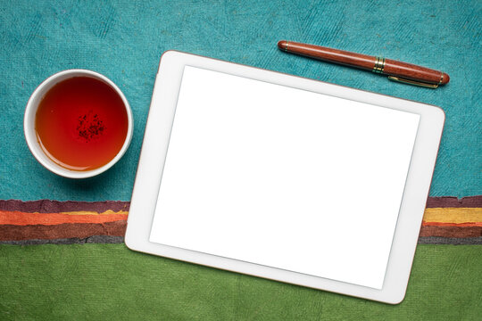 Mockup Of Digital Tablet With A Blank Isolated Screen (clipping Path Included), Flat Lay With A Cup Of Tea Against Abstract Paper Landscape