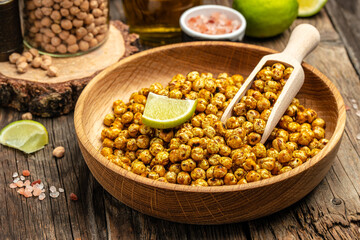 fried spicy chickpeas with lime on wooden table background. Food recipe background. Close up