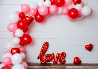 Valentine's Day balloon arch on white shiplap wall