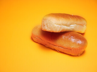 Hot dog buns on an isolated orange-yellow background.