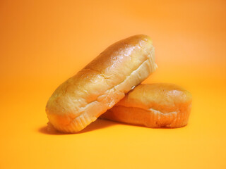 Hot dog buns on an isolated orange-yellow background.