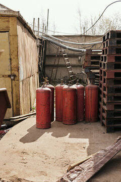 Vertical shot of gas bottles and other material outside welder&rsquo;s workshop