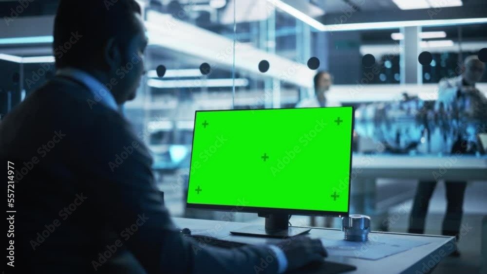 Fototapete Software Developer Working on Computer with Green Screen Mock Up Display. Scientific Lab, Engineering Research Center with Specialists Working on Turbine Engine Development in the Background.
