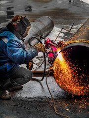 Working welder cuts metal and sparks fly. Gas cutting of large diameter pipes with acetylene and...