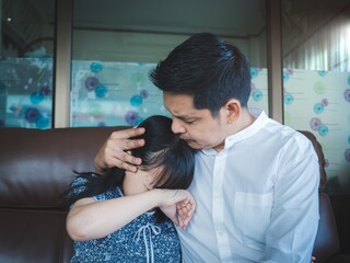 Loving daddy embracing small girl at home,Caring worry asian man hugging little daughter, Comforting his upset child,Father soothing crying depressed kid