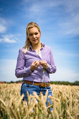 Junge Landwirtin mit nachdenklichem Blick im Getreidefeld.  © Countrypixel