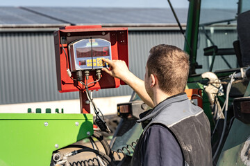  Landwirt programmiert die Steuerung an einem Futtermischwagen.