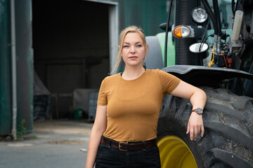 Junge Auszubildene in der Landwirtschaft steht am Treckerrad und denkt über ihre Ziele nach. © Countrypixel