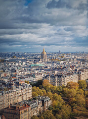 Fototapeta na wymiar Scenery aerial view from the Eiffel tower height over the Paris city, France. Les Invalides building with golden dome seen on the horizon. Autumn parisian cityscape