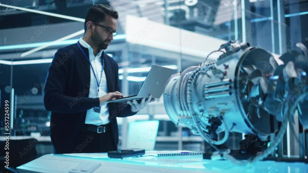 Poster Chief Engineer Using Laptop Computer, Analyzing and Researching How a Futuristic Turbofan Motor Works. Senior Manager Developing Innovative Technology in Industrial High Tech Facility.