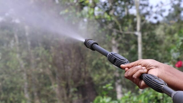 High pressure washer with water jet on outdoors pointed towards nature