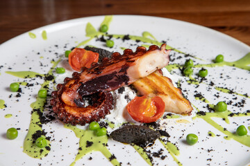 Polpo alla griglia con piselli e quenelle al nero si seppia