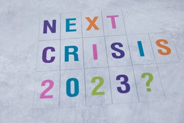 Next crisis 2023. Colorful letters on concrete background. Symbol image for the next crisis to...