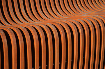 Curved wooden slats. Beautiful brown surface. Abstract background.