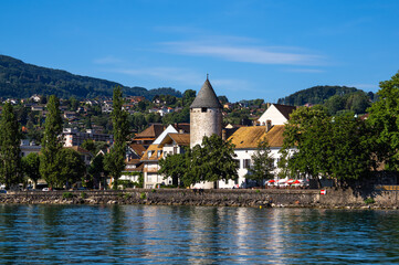 Fototapeta na wymiar Vevey, Switzerland - July 14, 2022: View from Lake Geneva to the old town of Vevey with its medieval tower