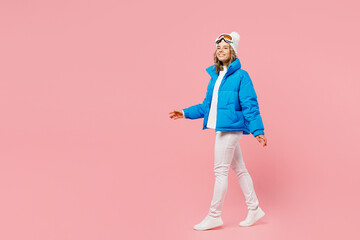 SIde view smiling fun snowboarder woman wear blue suit goggles mask hat ski padded jacket walking...
